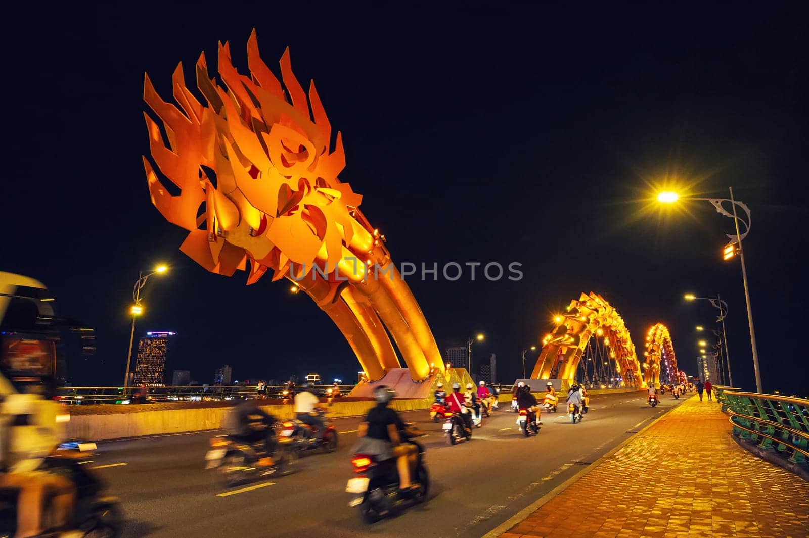Motorcycle traffic on the Dragon Bridge over the Han River in Da Nang, Vietnam at night