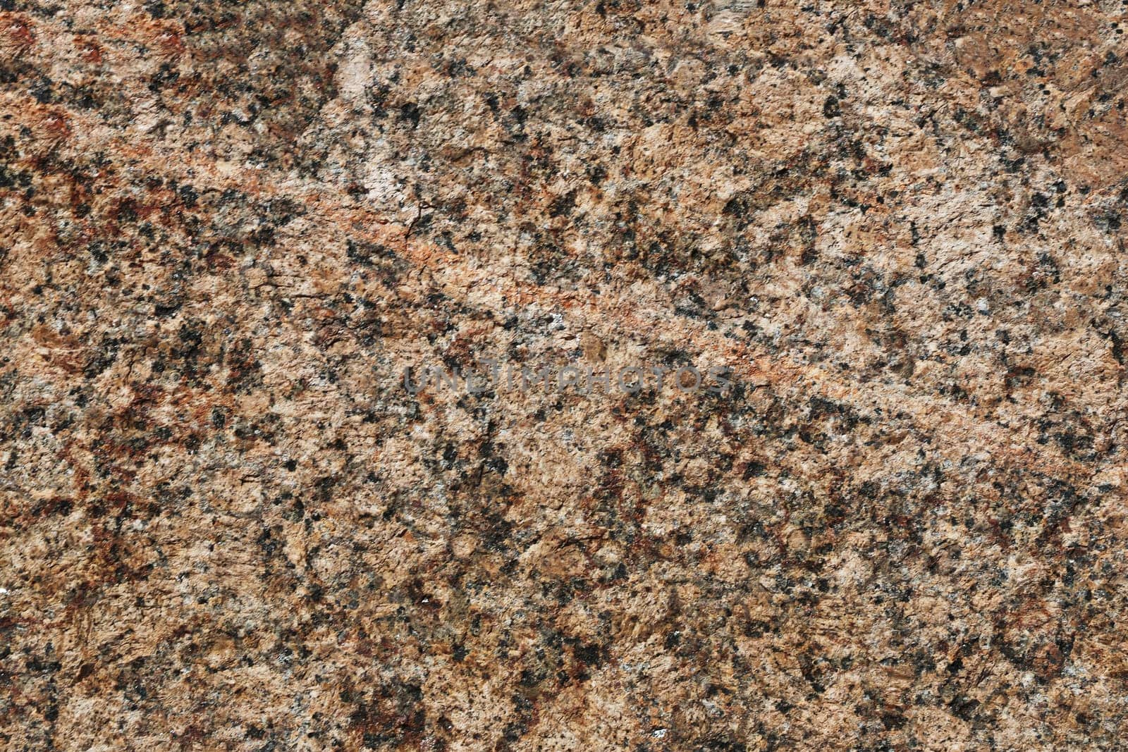 Granite texture. Natural red granite with a grainy pattern. Stone background. Solid rough surface of rock.