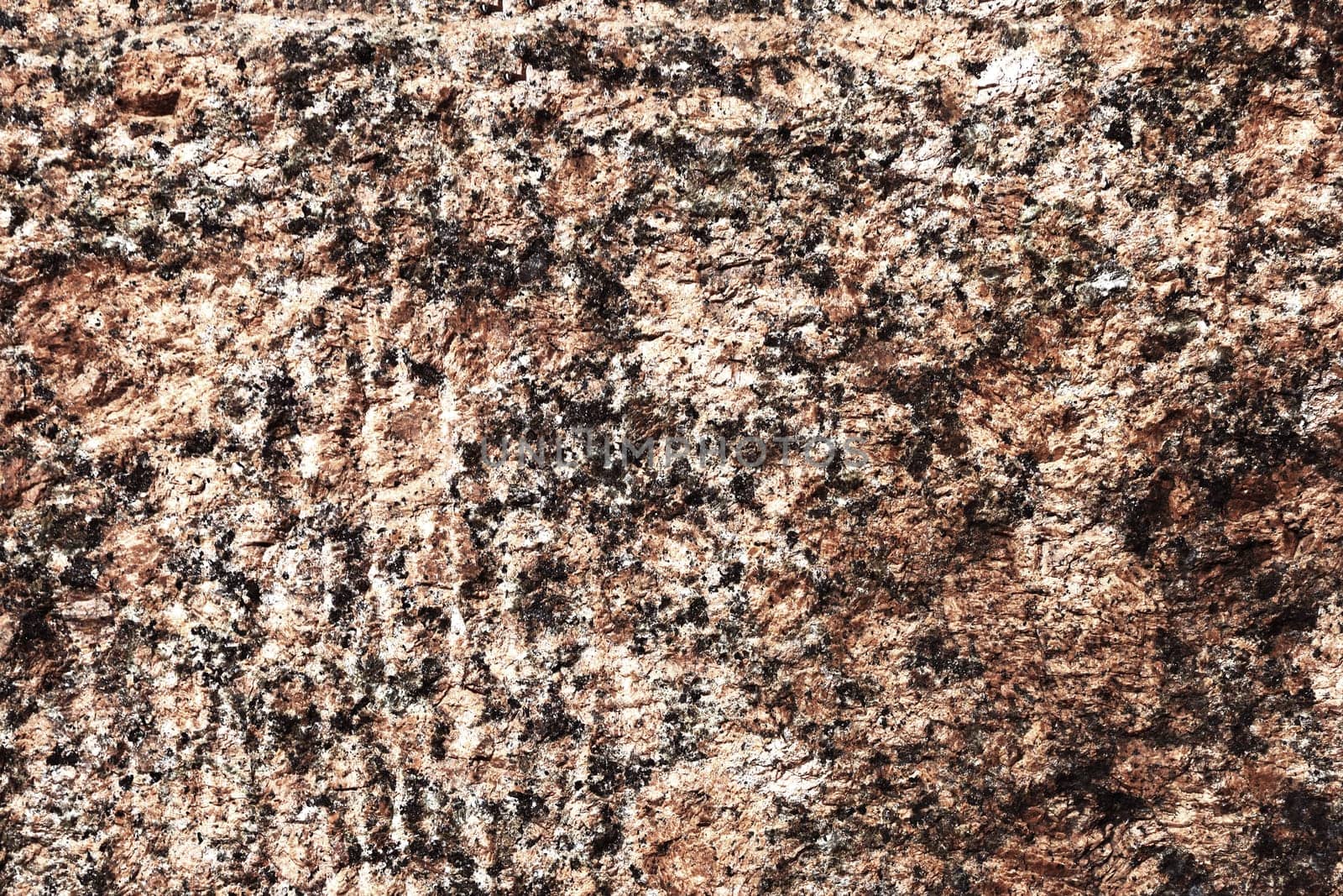 Brown stone wall close up. Wall surface made of granite.