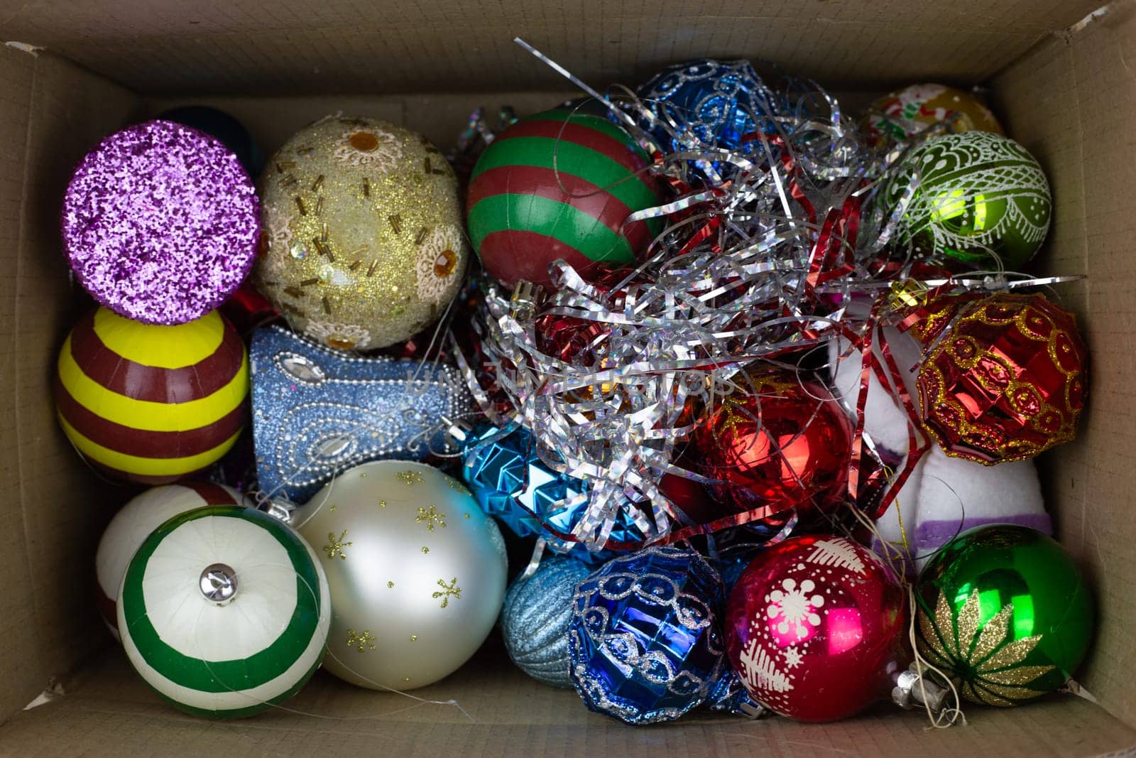 Cardboard box with New Year toys inside, top view. Christmas toys in box for decorating festive tree for New Year, storing New Year attributes at home