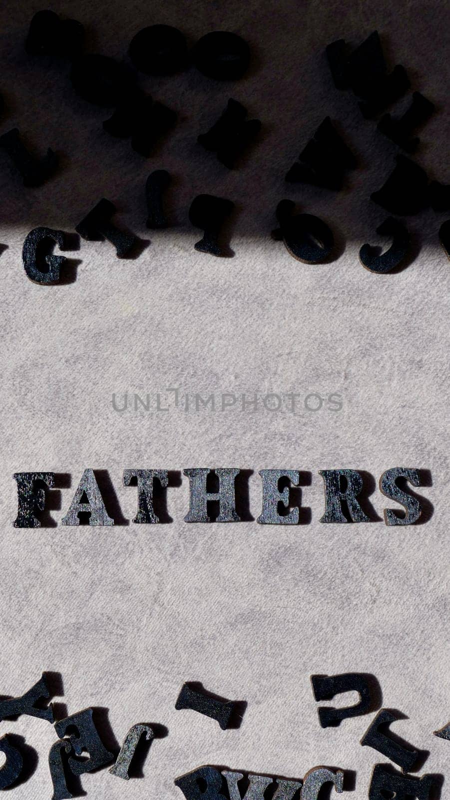 Lettering father in black letters on grey background on father's day close-up