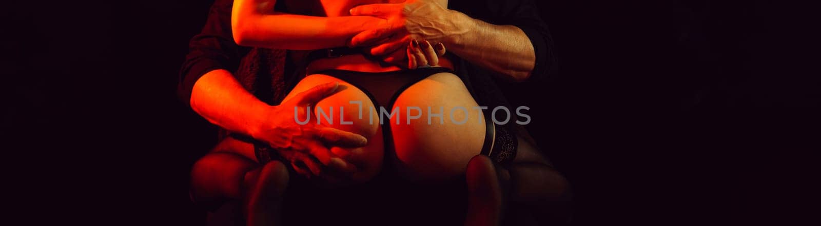 passionate foreplay between a man and a girl. Male hands wildly squeeze the girl's bum. Panoramic wide horizontal photo for banner head cover