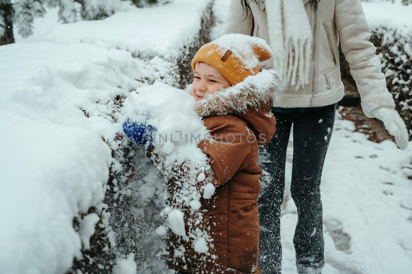 Happy little child boy playing in the park in winter