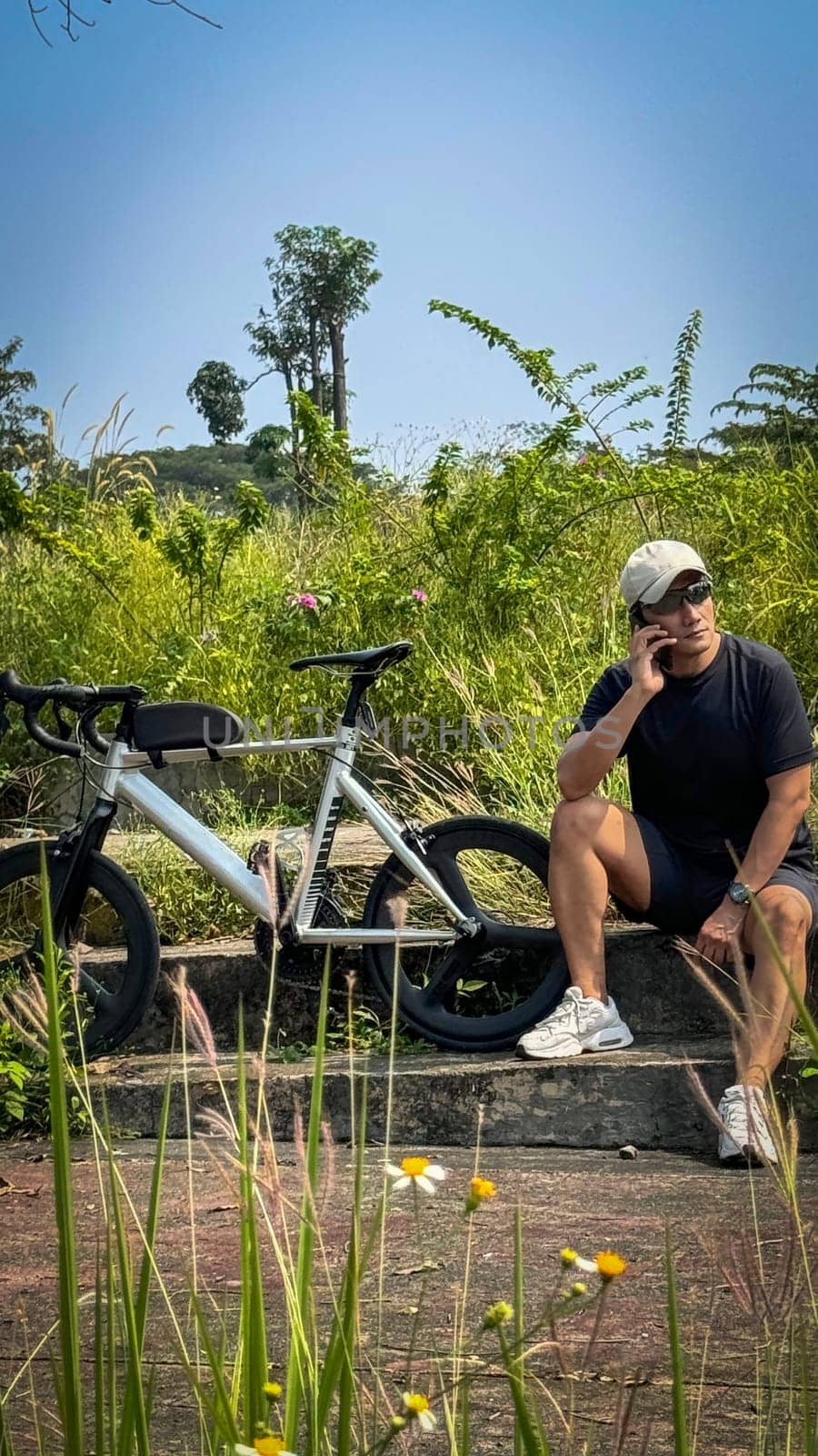 Healthy lifestyle, bicycle sport and exercise, a man in casual sportswear rides a bicycle on a sunny day surrounded by lush greenery, the image captures a sense of relaxation and outdoor adventure, good for health and sport article or content creation