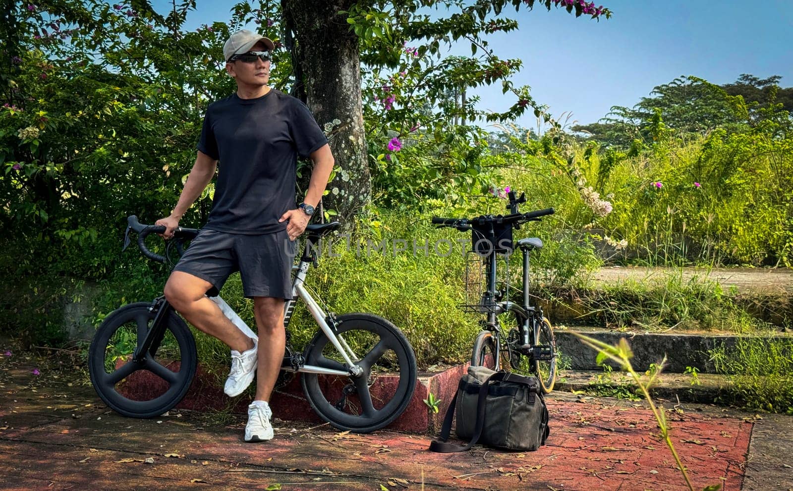 Healthy lifestyle, bicycle sport and exercise, a man in casual sportswear rides a bicycle on a sunny day surrounded by lush greenery, the image captures a sense of relaxation and outdoor adventure, good for health and sport article or content creation