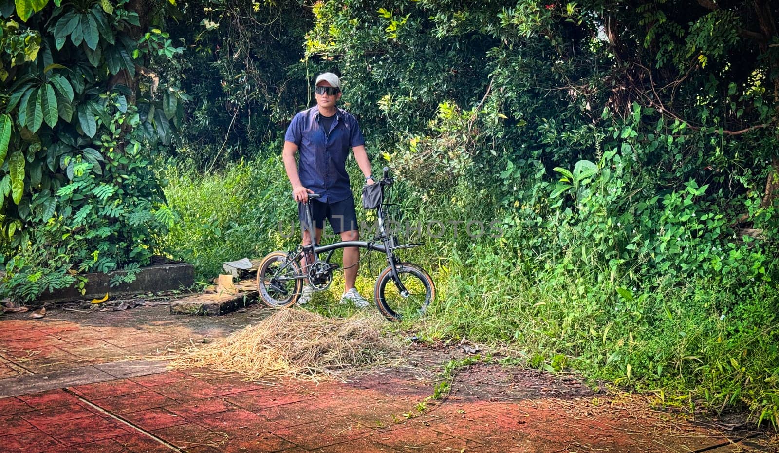 Healthy lifestyle, bicycle sport and exercise, a man in casual sportswear rides a bicycle on a sunny day surrounded by lush greenery, the image captures a sense of relaxation and outdoor adventure, good for health and sport article or content creation