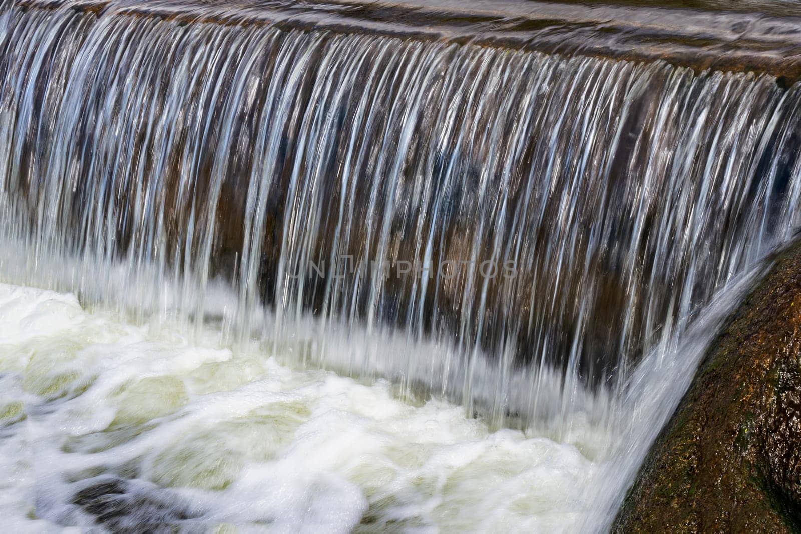 Cascading waterfall closeup. Flowing water in a cascading waterfall.