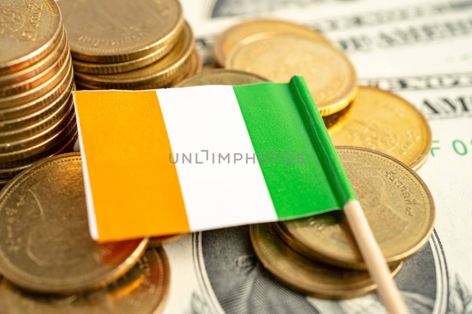 Stack of coins with Ireland flag and US dollar banknotes. by pamai