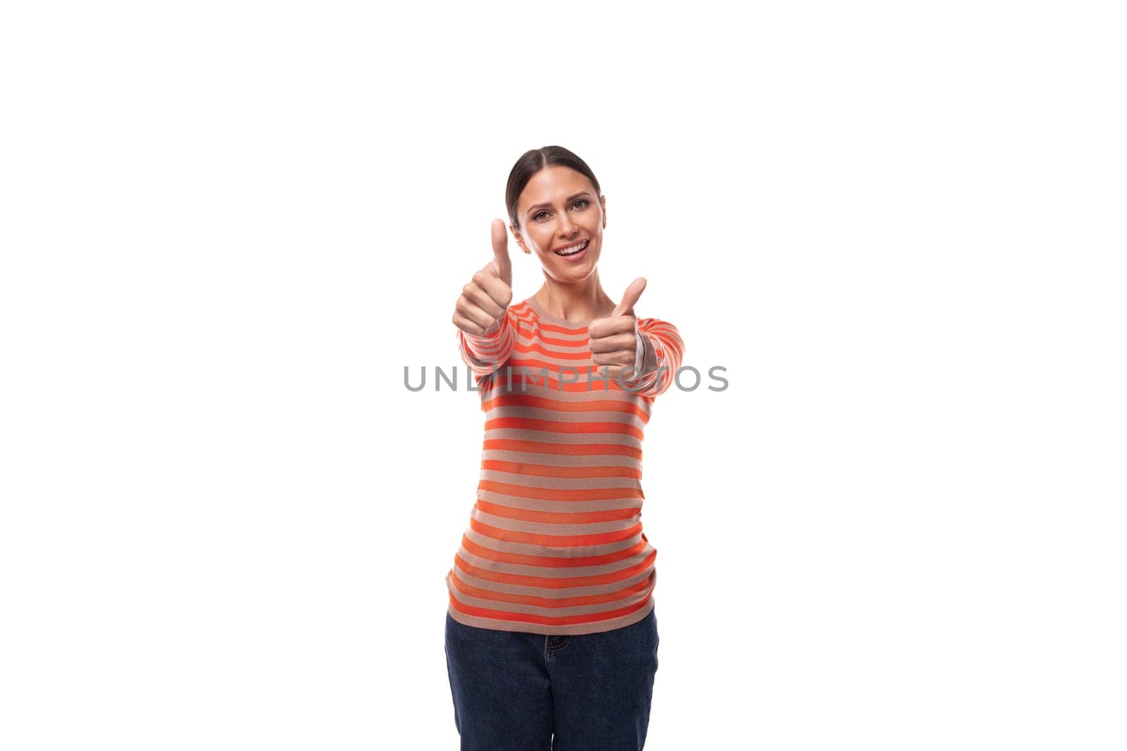 a pretty young adult woman with black hair dressed in an orange sweater is actively gesturing on a white background with copy space.