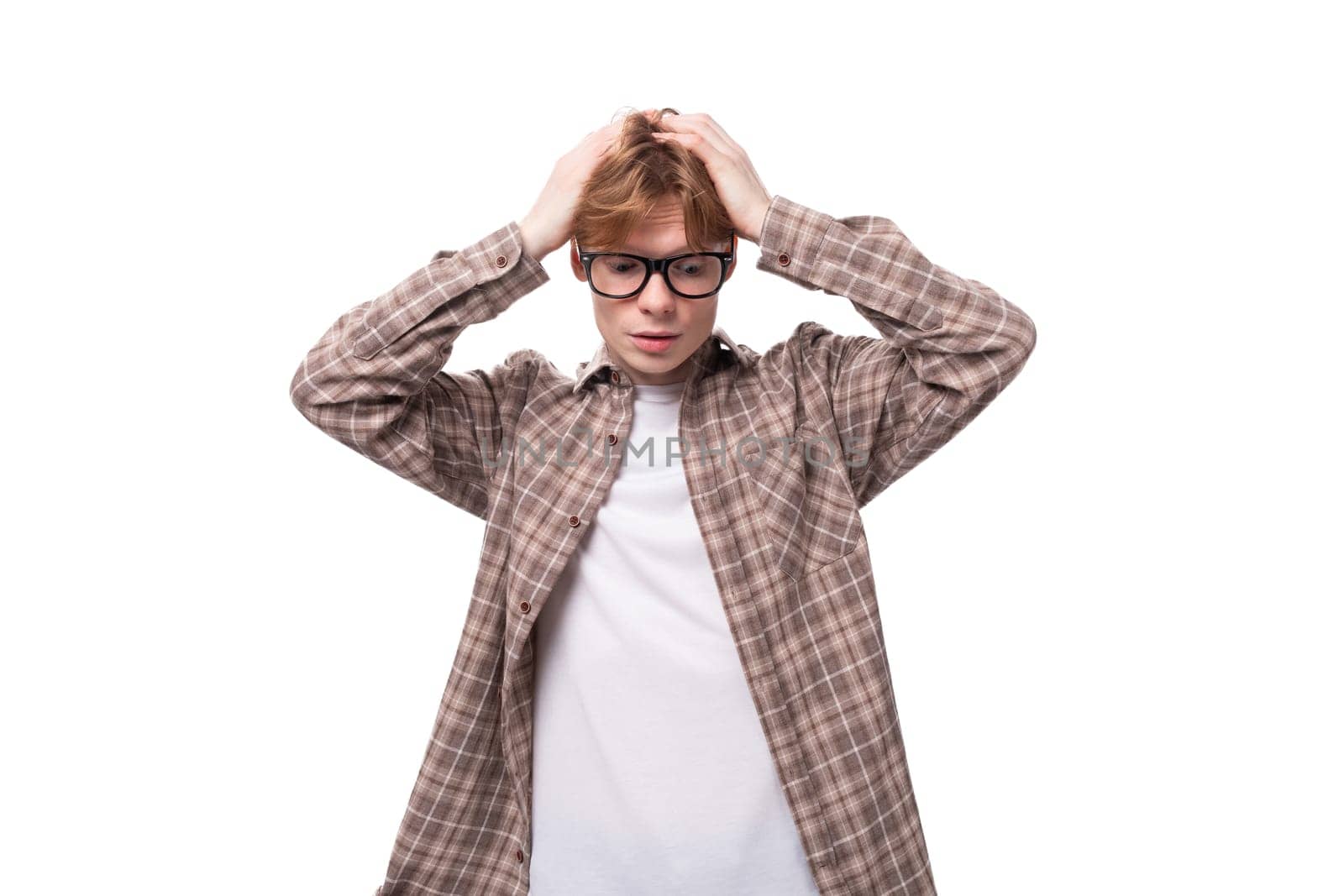 young surprised caucasian red-haired guy in a shirt on a white background with copy space by TRMK