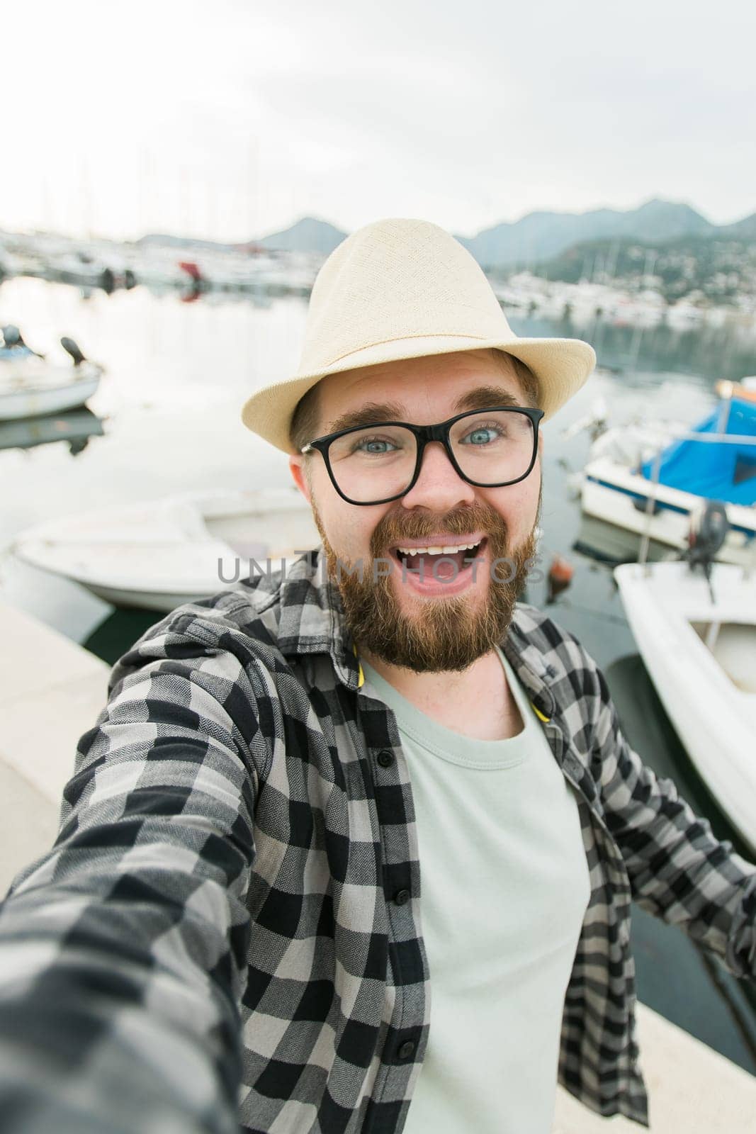 Traveller millennial man taking selfie of luxury yachts marine during sunny day - travel and videocall and blogging concept by Satura86