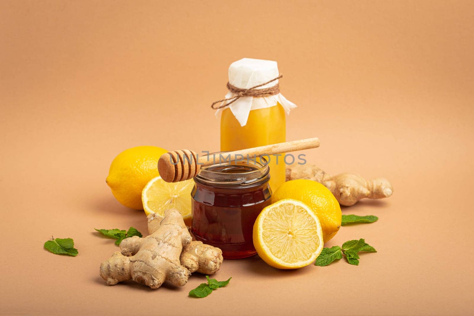 Composition with detox drink, sea buckthorn berries, lemons, mint, ginger, honey in glass jar. Food for immunity stimulation and against flu. Healthy natural remedies to boost immune system by its_al_dente