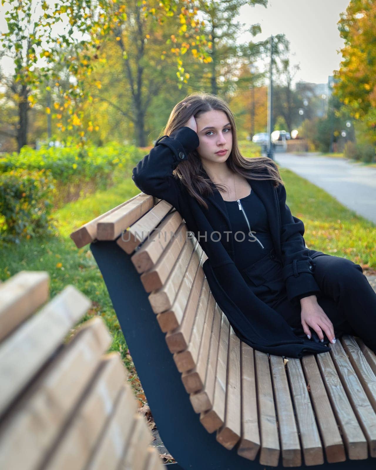 A beautiful girl posing on a bench in an autumn park. by Yurich32