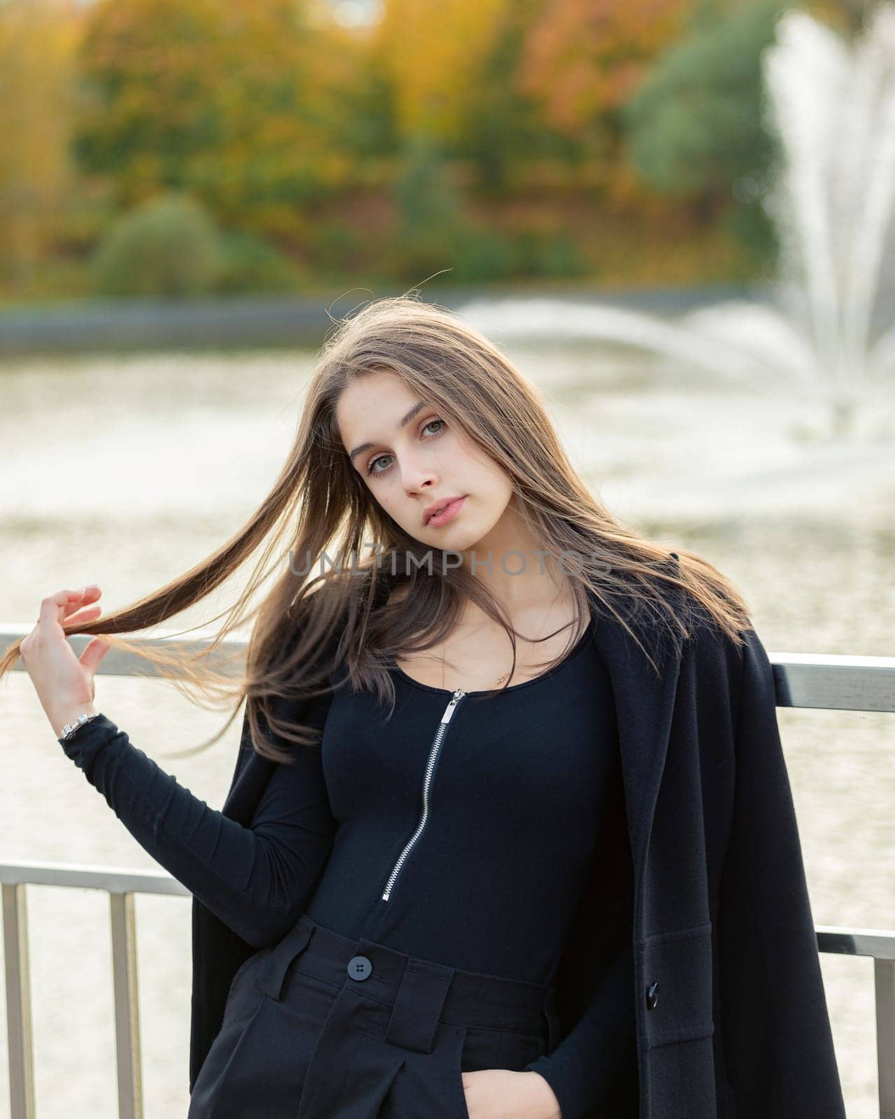 Portrait of a girl on a bridge near a pond in a city park. by Yurich32