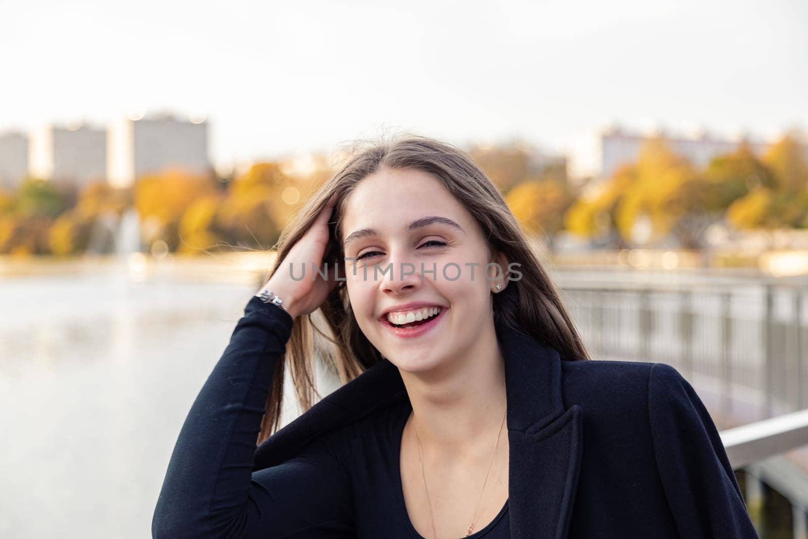 Portrait of a girl on a bridge near a pond in a city park against the backdrop of fountains. by Yurich32