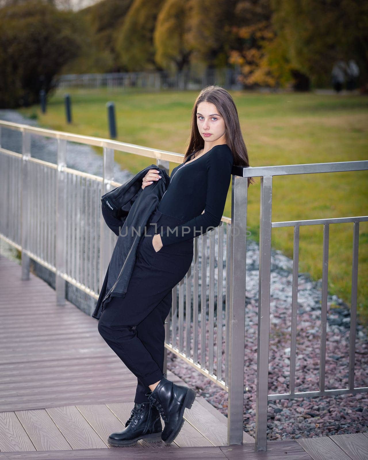 A girl poses on a bridge in a city park. by Yurich32