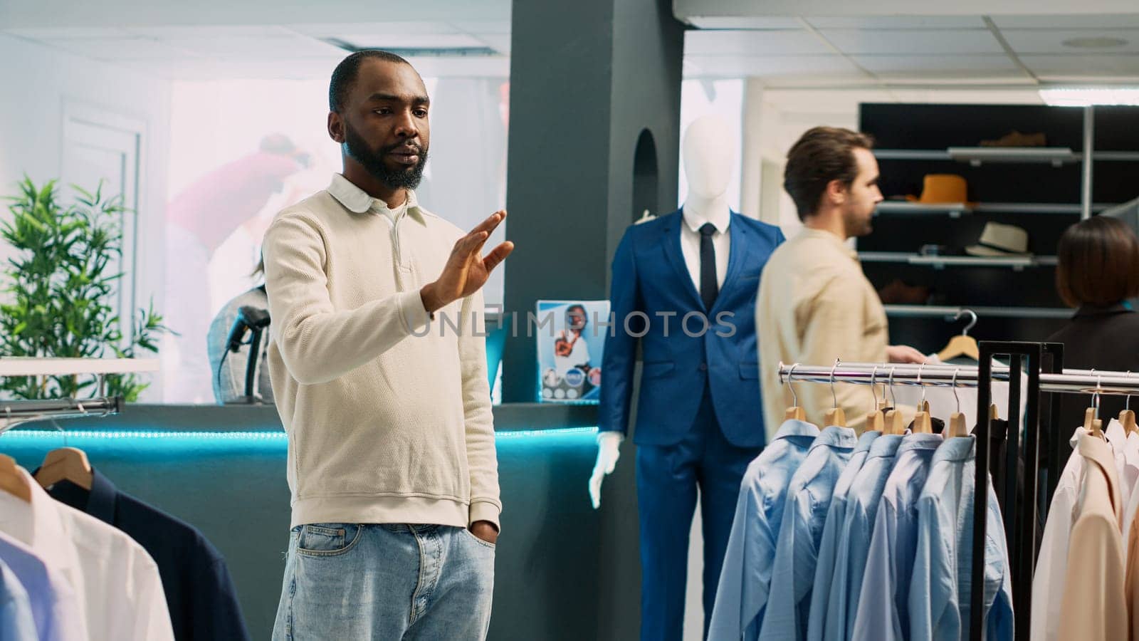 African american man looking at hologram in store by DCStudio