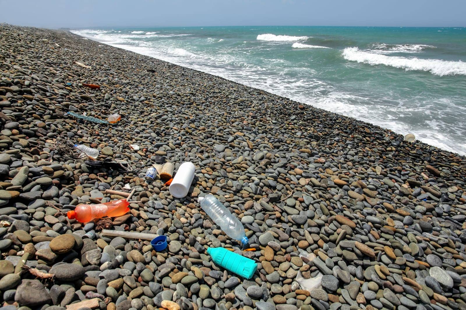 Plastic bottles rubbish on wild pebbles beach. Ocean and sea littering concept by Ivanko