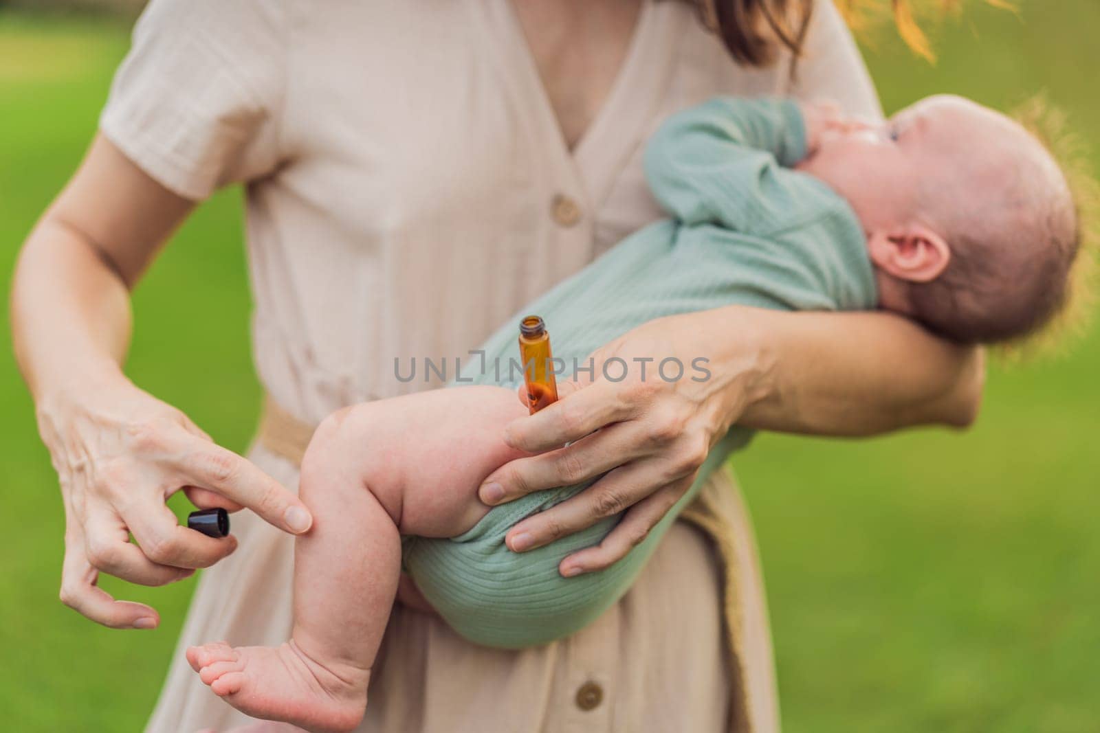Loving mother gently applies soothing aroma oils to her precious newborn, creating a calming and nurturing atmosphere by galitskaya