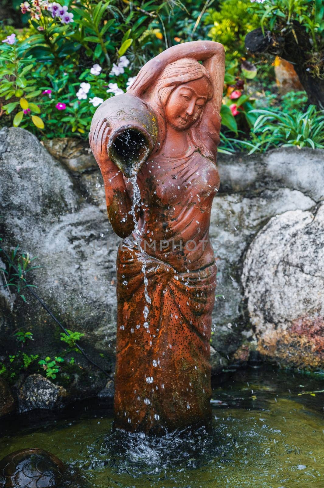 statue of a woman with a jug in a fountain on a pagoda in Asia