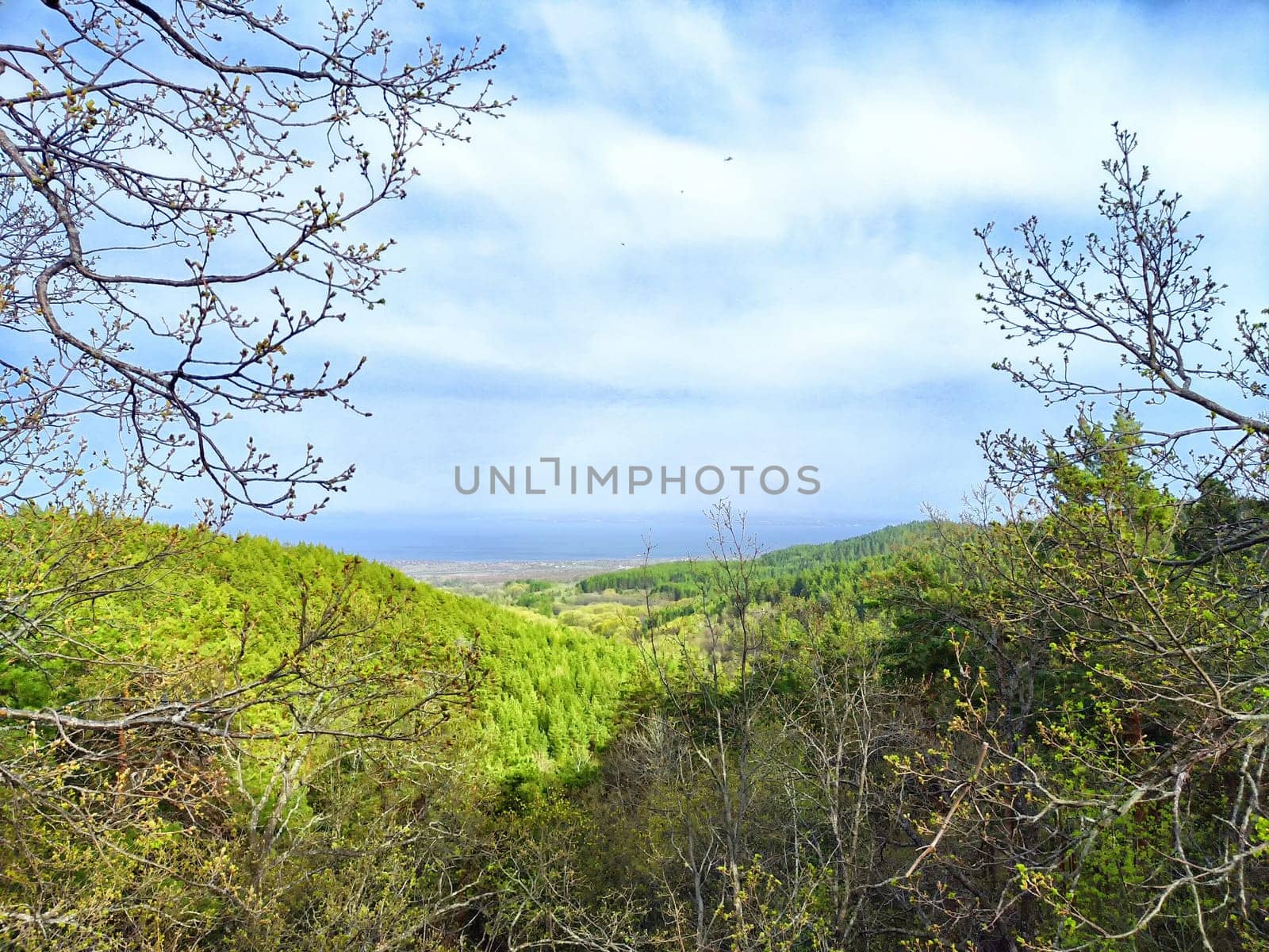 Lush green hills stretch into the distance beneath a partly cloudy sky.