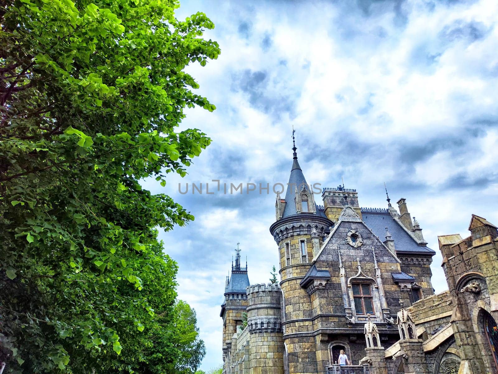 A stone castle with tall towers and cloudy sky