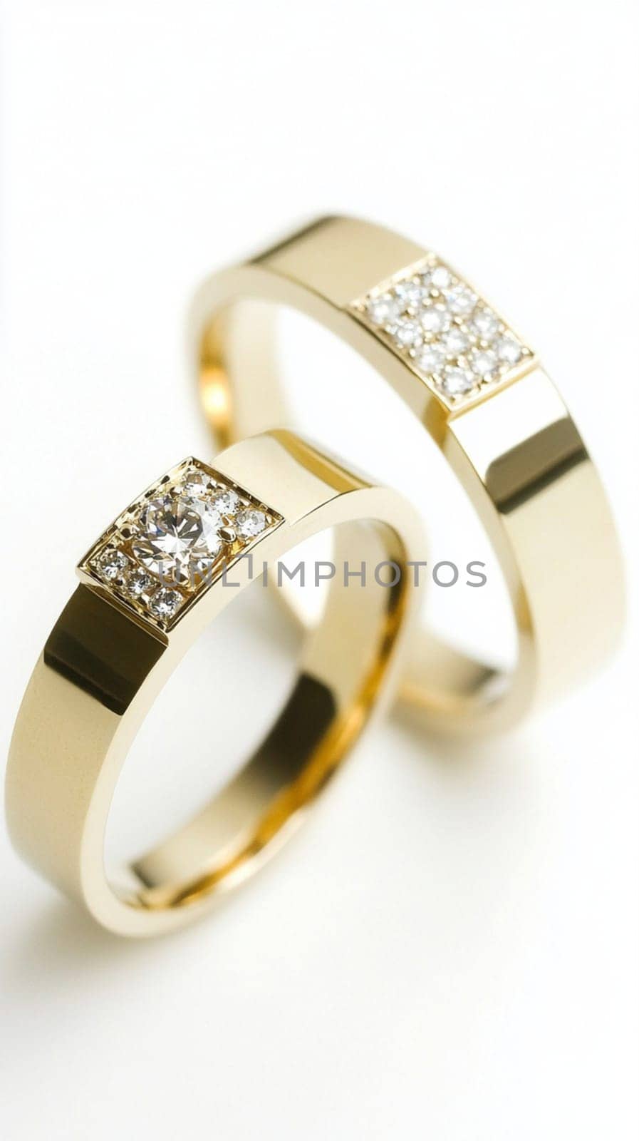 Two simple gold wedding rings are laying on white cloth, ready for the couple to exchange during their wedding ceremony