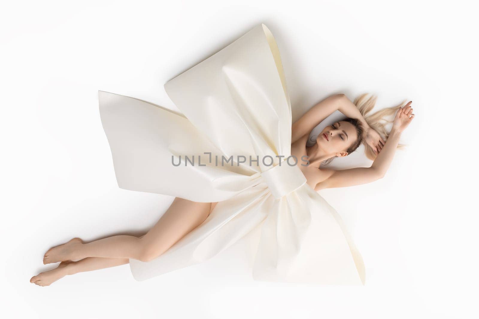 Nude girl on the floor with huge decorative bow high angle shot