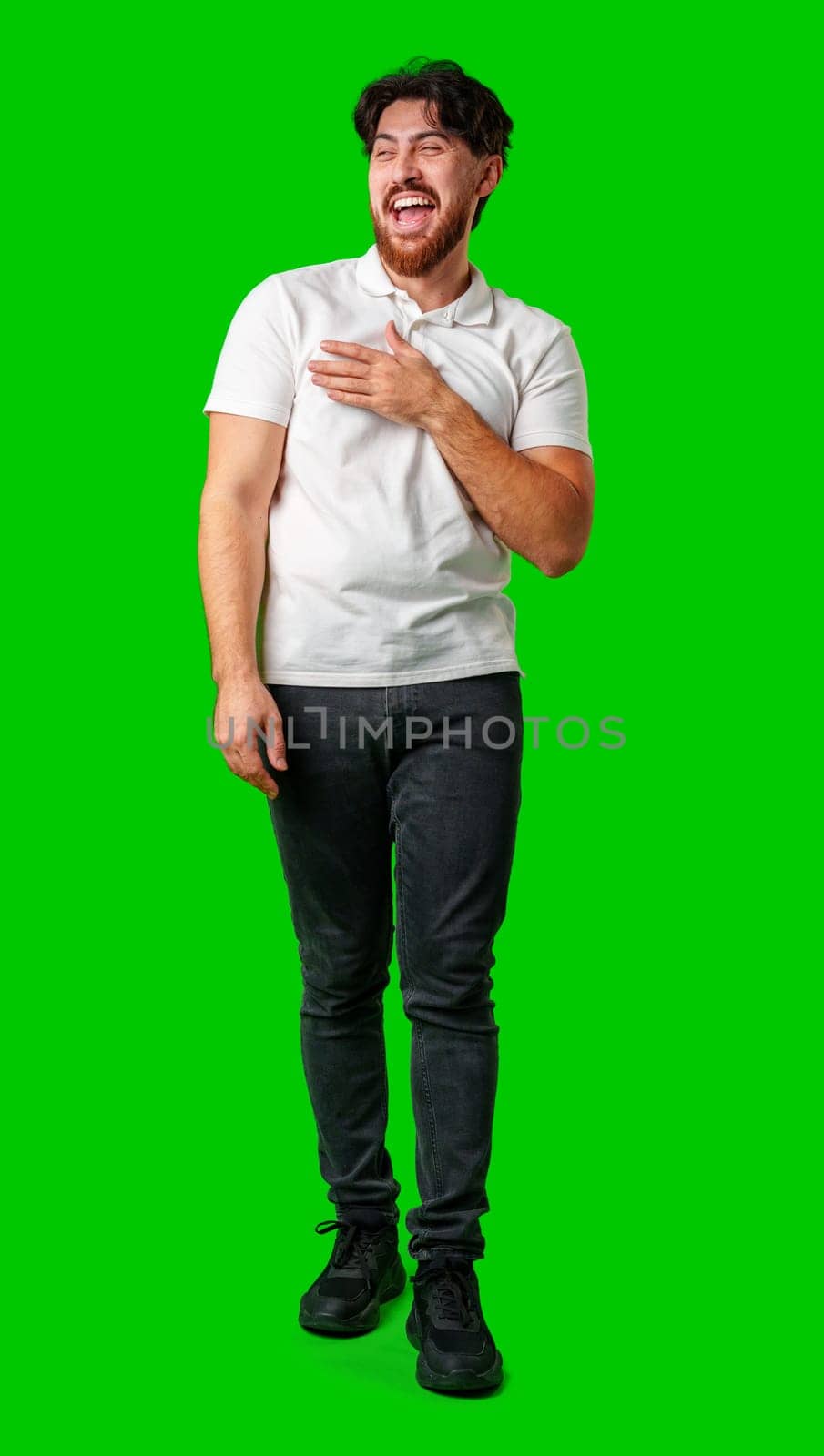 Young man expresses surprise in front of a bright green background studio shot