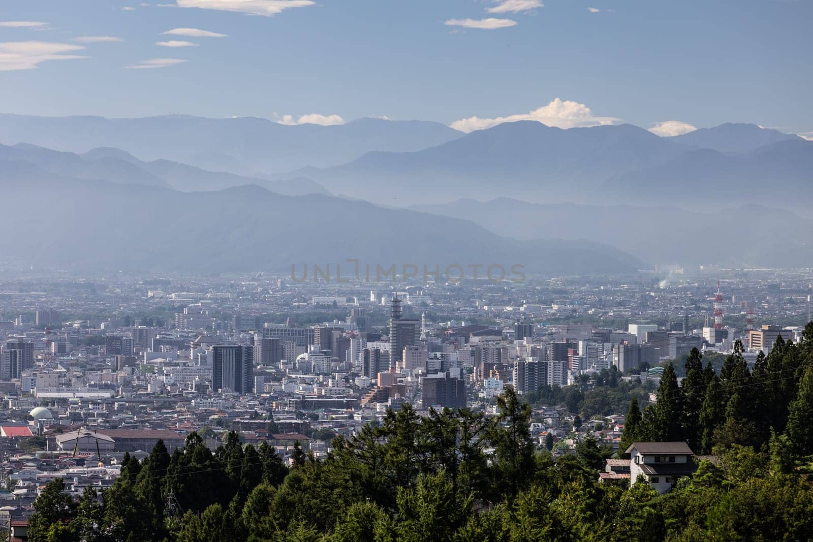 NAGANO, JAPAN - SEPTEMBER 20, 2024: An aerial view over the beautiful town of Nagano in Nagano Prefecture. Surrounded by mountains on a clear warm autumn morning.