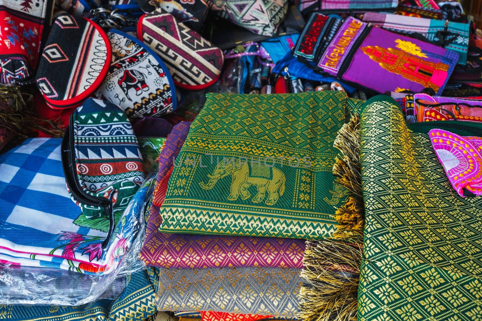 Colorful bags and various textiles on the counter at a street bazaar in Vietnam in Asia