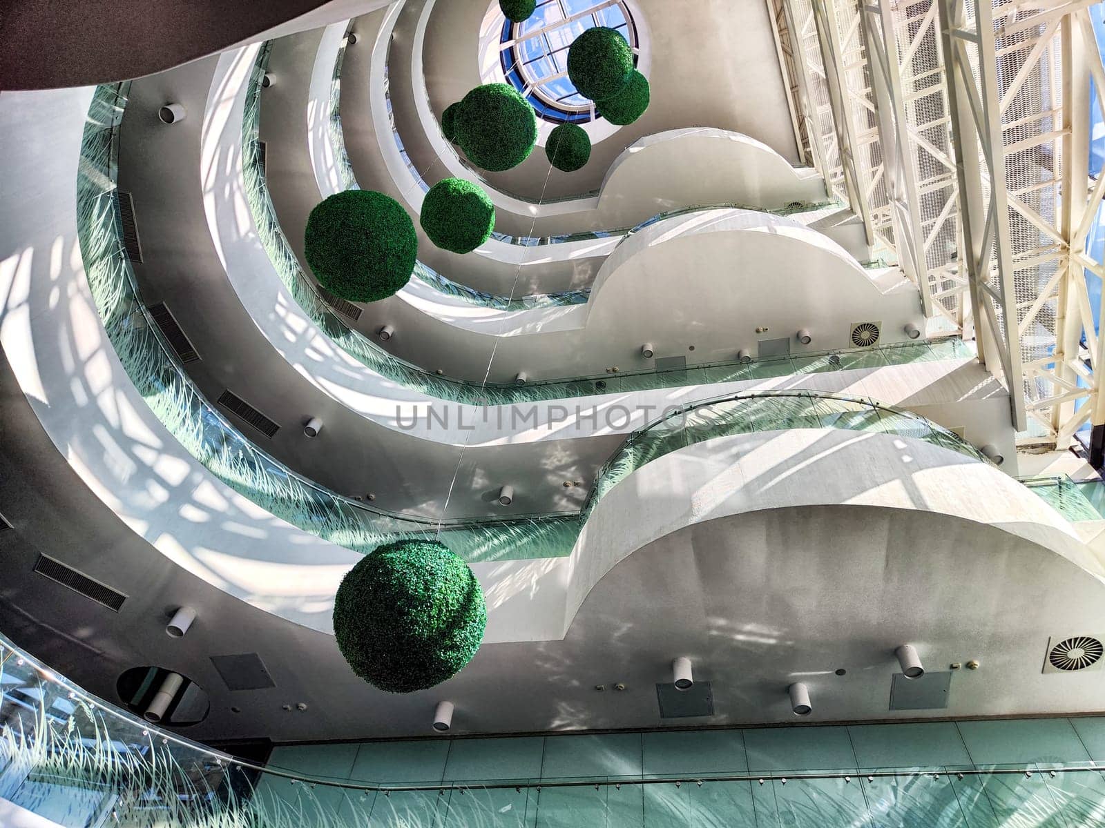 The unique interior design showcases green spherical decorations and smooth curves in a contemporary structure, inviting exploration.