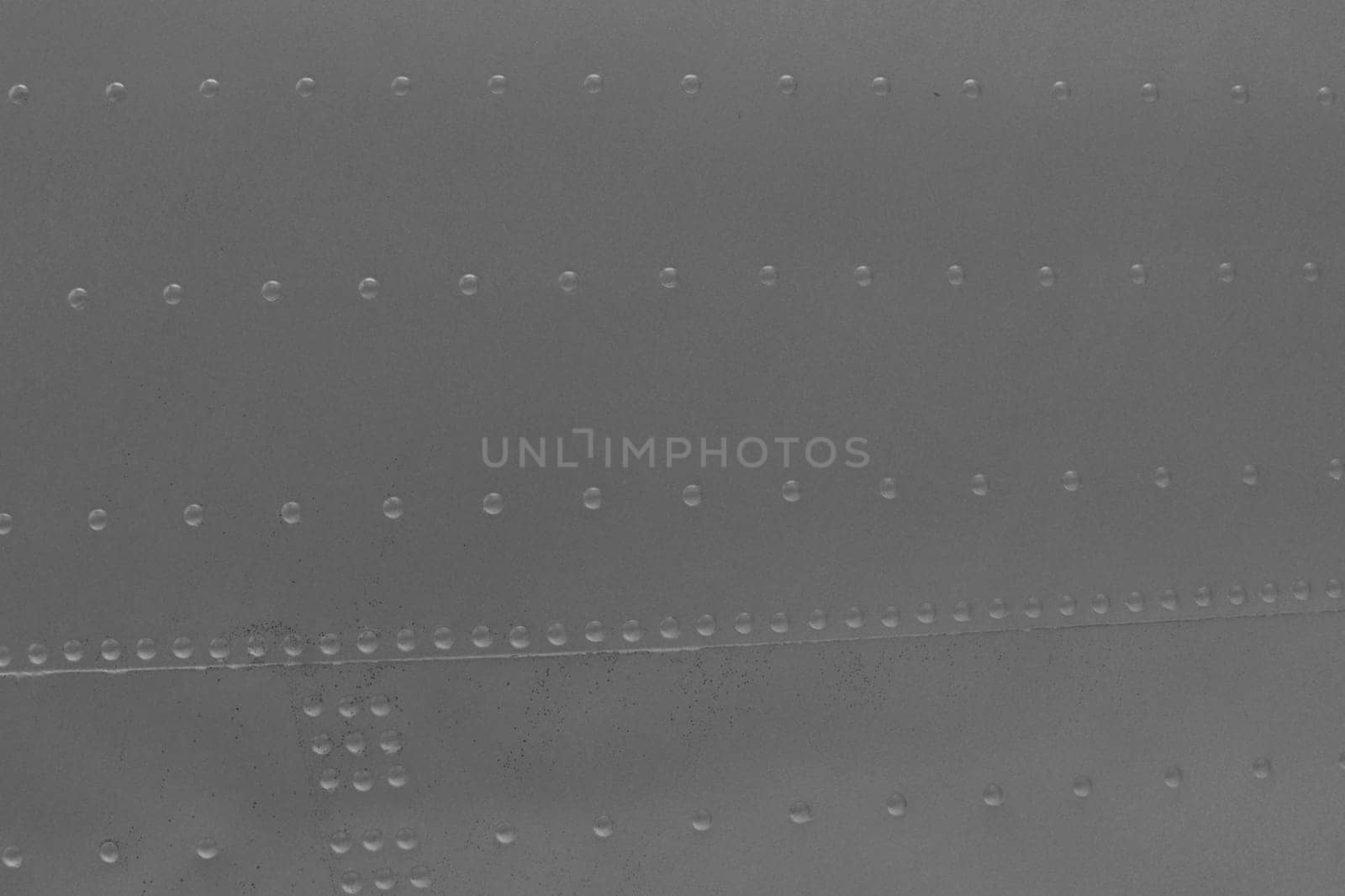 A fragment of a military airplane fuselage. Close-Up of Gray Metal. Metal abstract background.