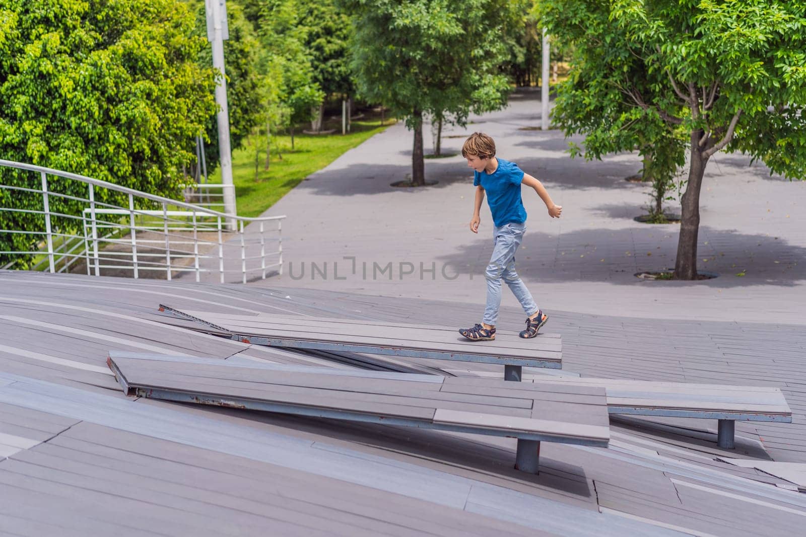 Teenage boy doing parkour in a park. Adventure, movement, and urban sport concept.