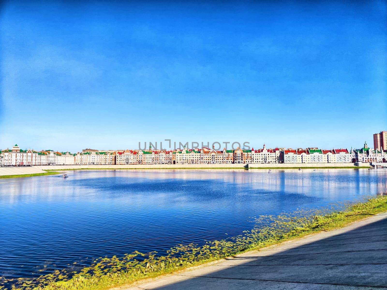 Charming houses line the waterways of Yoshkar-Ola, reflecting in the calm waters on a sunny day.