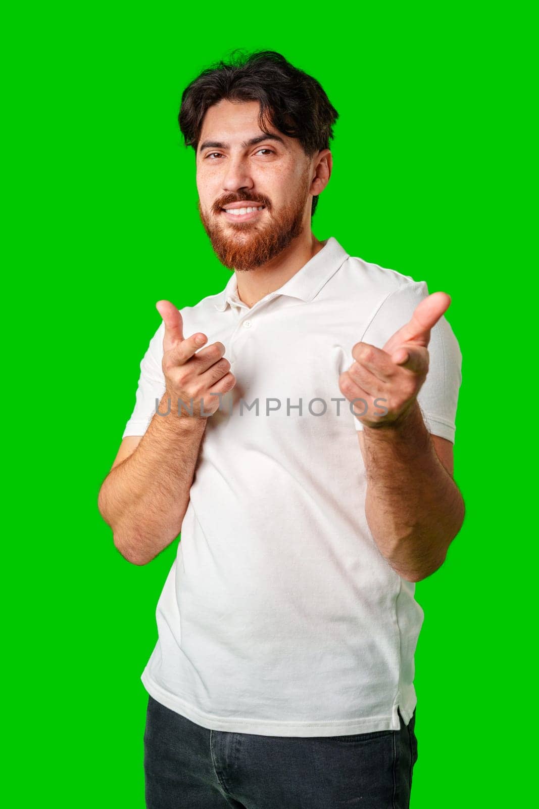 Smiling man gestures playfully with finger guns against a vibrant green background close up