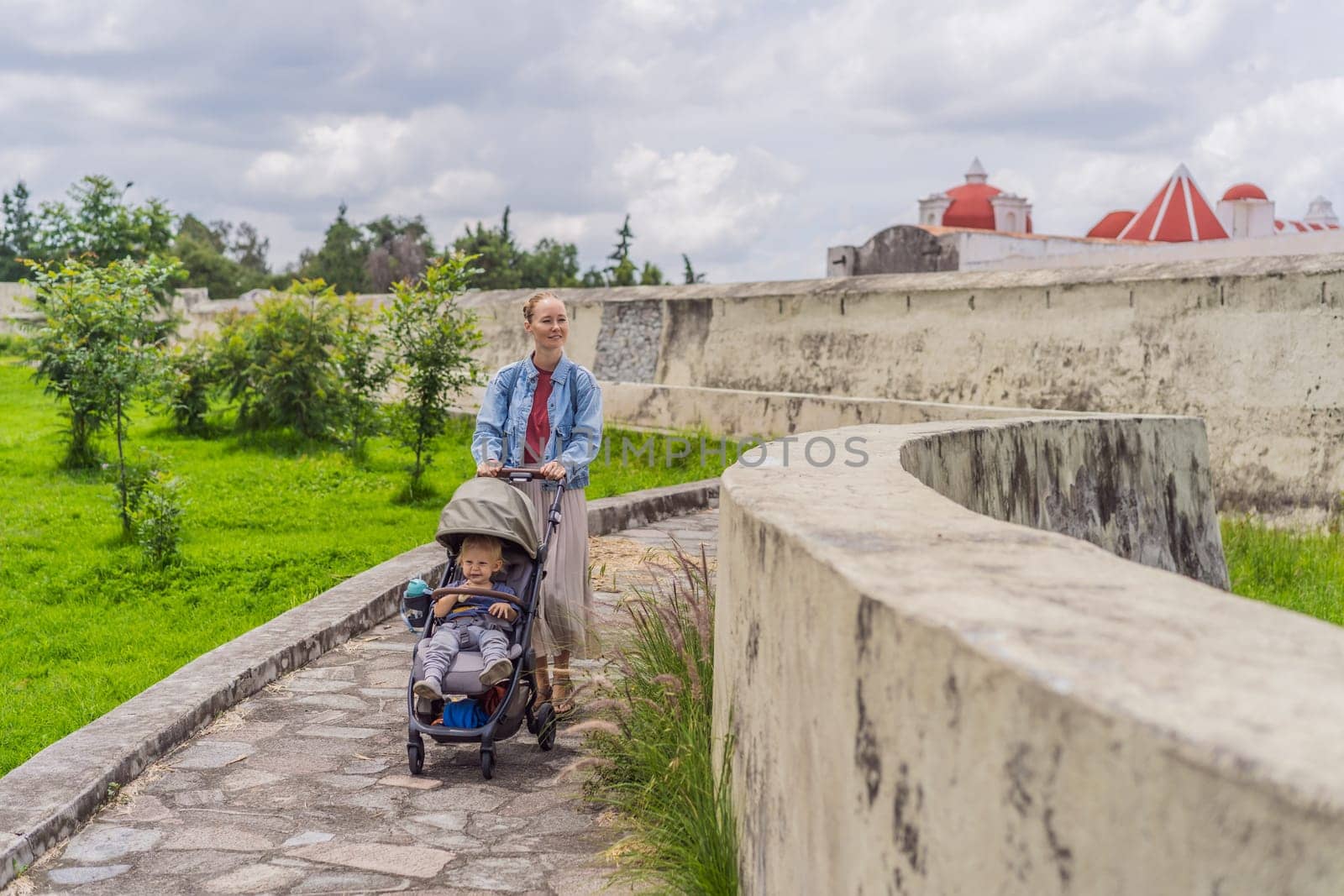 Mom and her baby son tourists exploring the Loreto Fort Museum in Puebla, Mexico. Cultural heritage, history, and travel exploration concept.