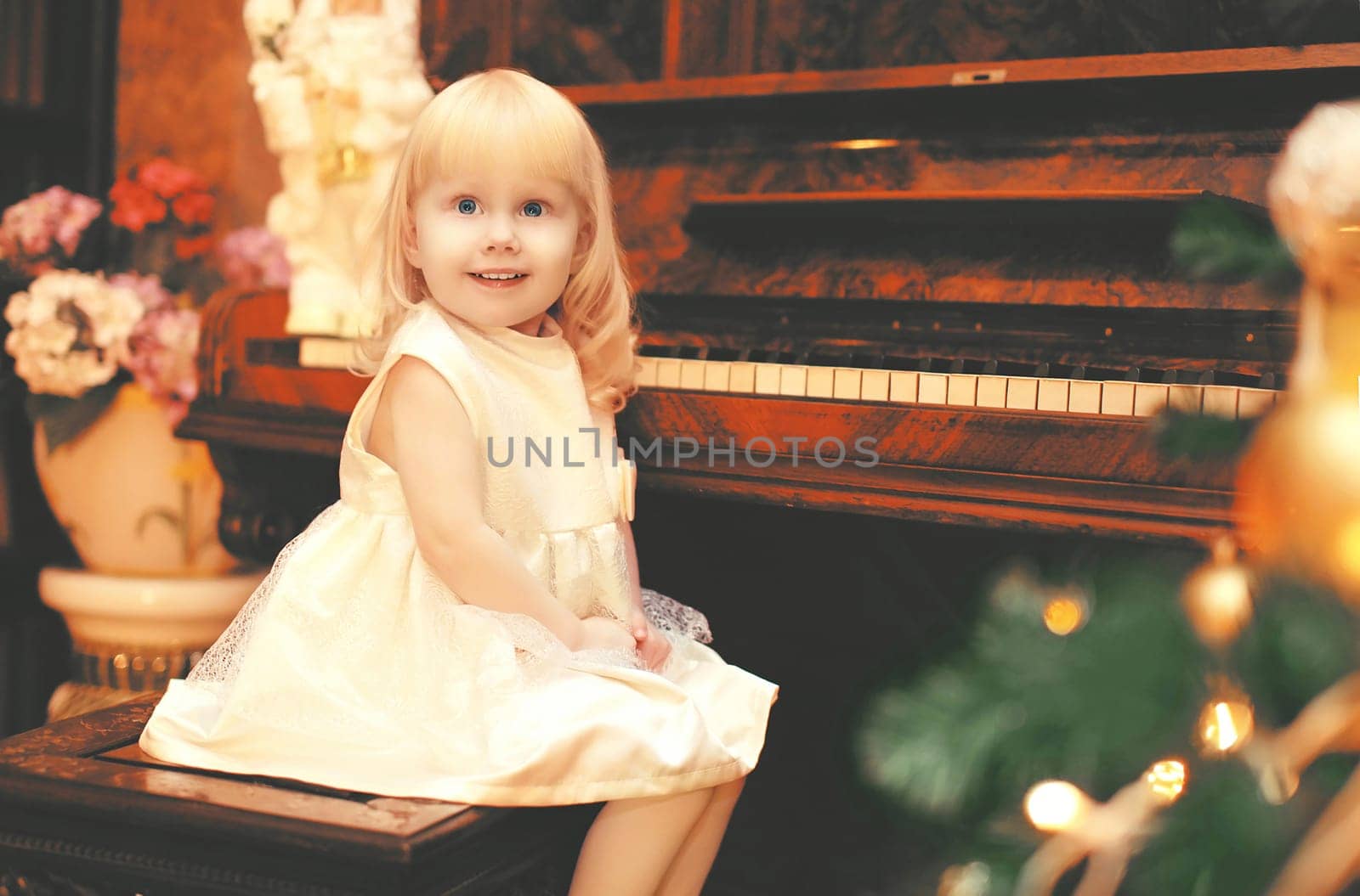 christmas smiling child little girl playing on piano at home