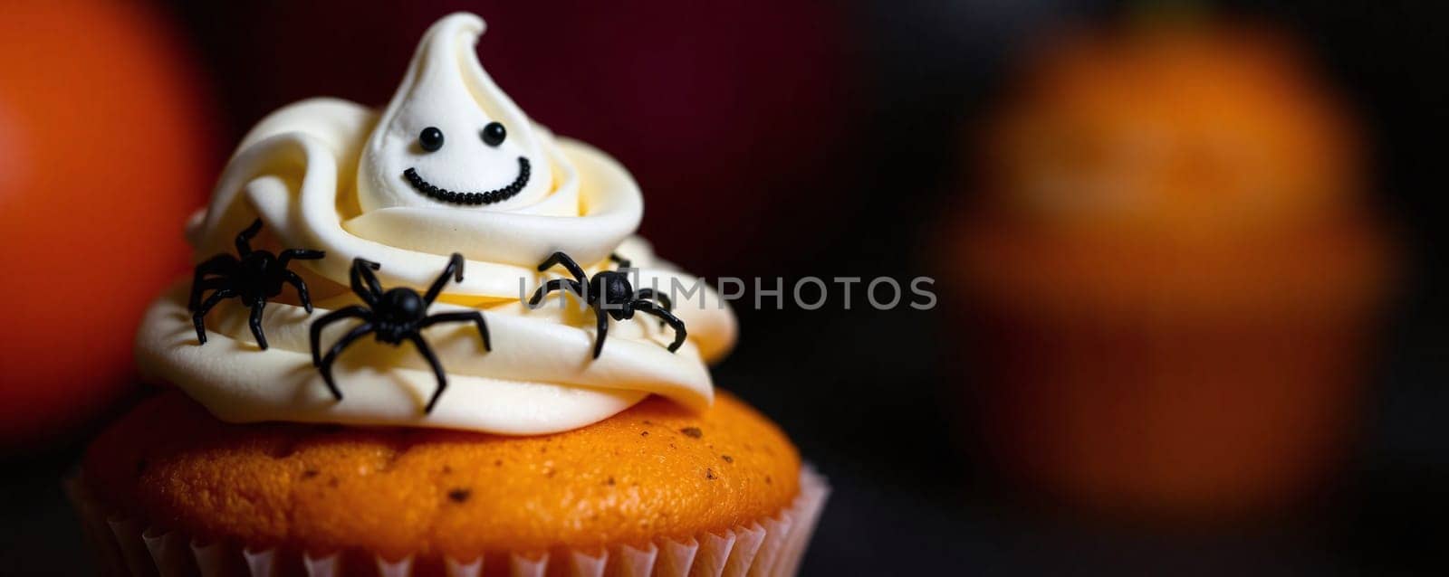 A pumpkin-flavored cupcake features ghostly white frosting topped with a smiling face and black spider decorations, perfect for Halloween festivities and celebrations.