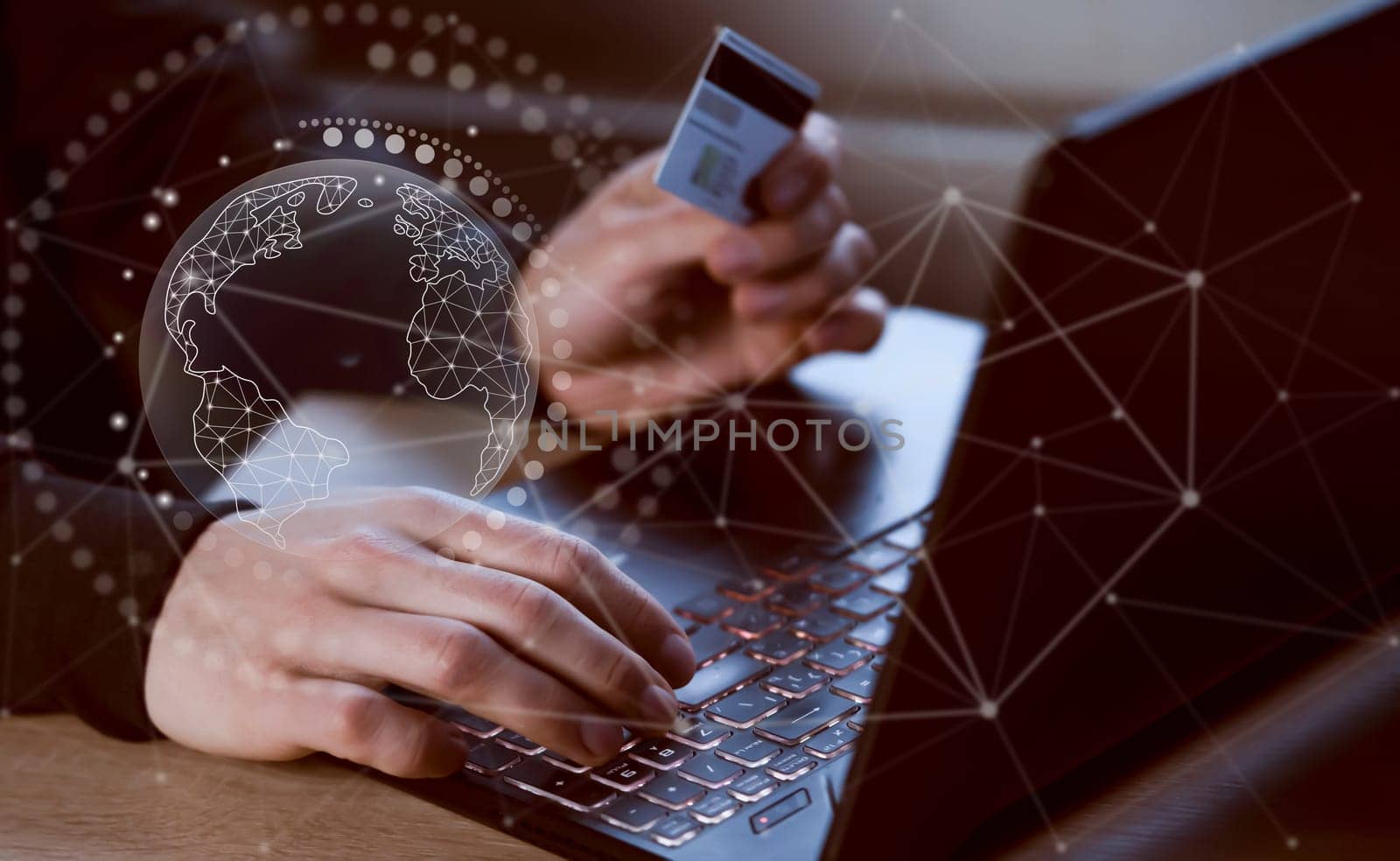 A man holds a bank card in his hand and types on a laptop keyboard, top view. Businessman makes banking transactions online, padlock sign, scheme drawn over.