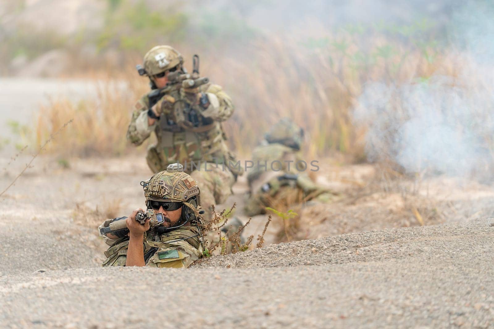 Group of military or soldiers hold the gun and point to the front and ready to fight with enemy during outdoor practice.