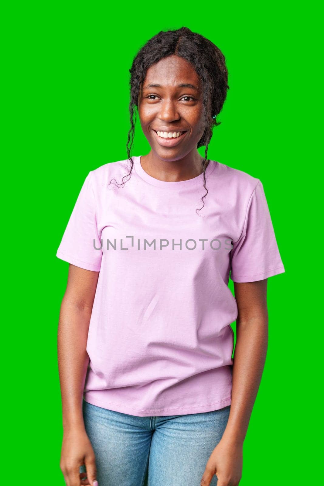 Young woman smiling joyfully in a pink shirt against a vibrant green background in a cheerful atmosphere close up