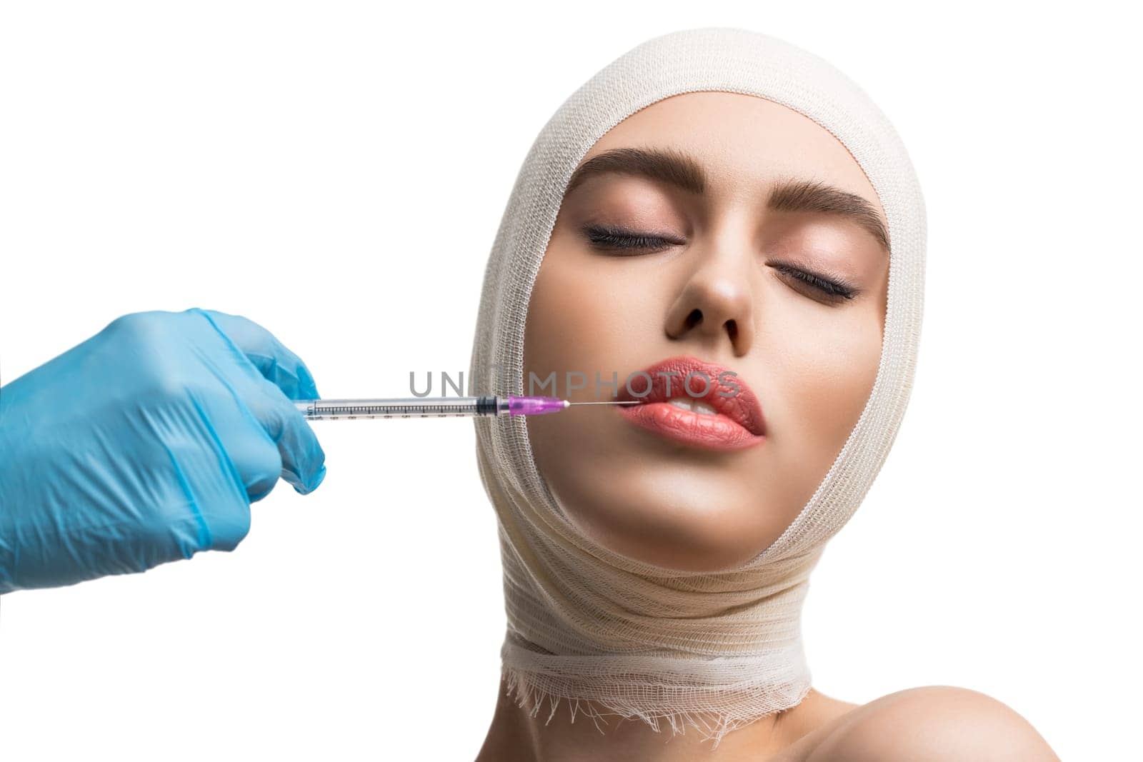 Girl her head and neck bandaged getting beauty lips injection at plastic surgeon isolated shot on white background