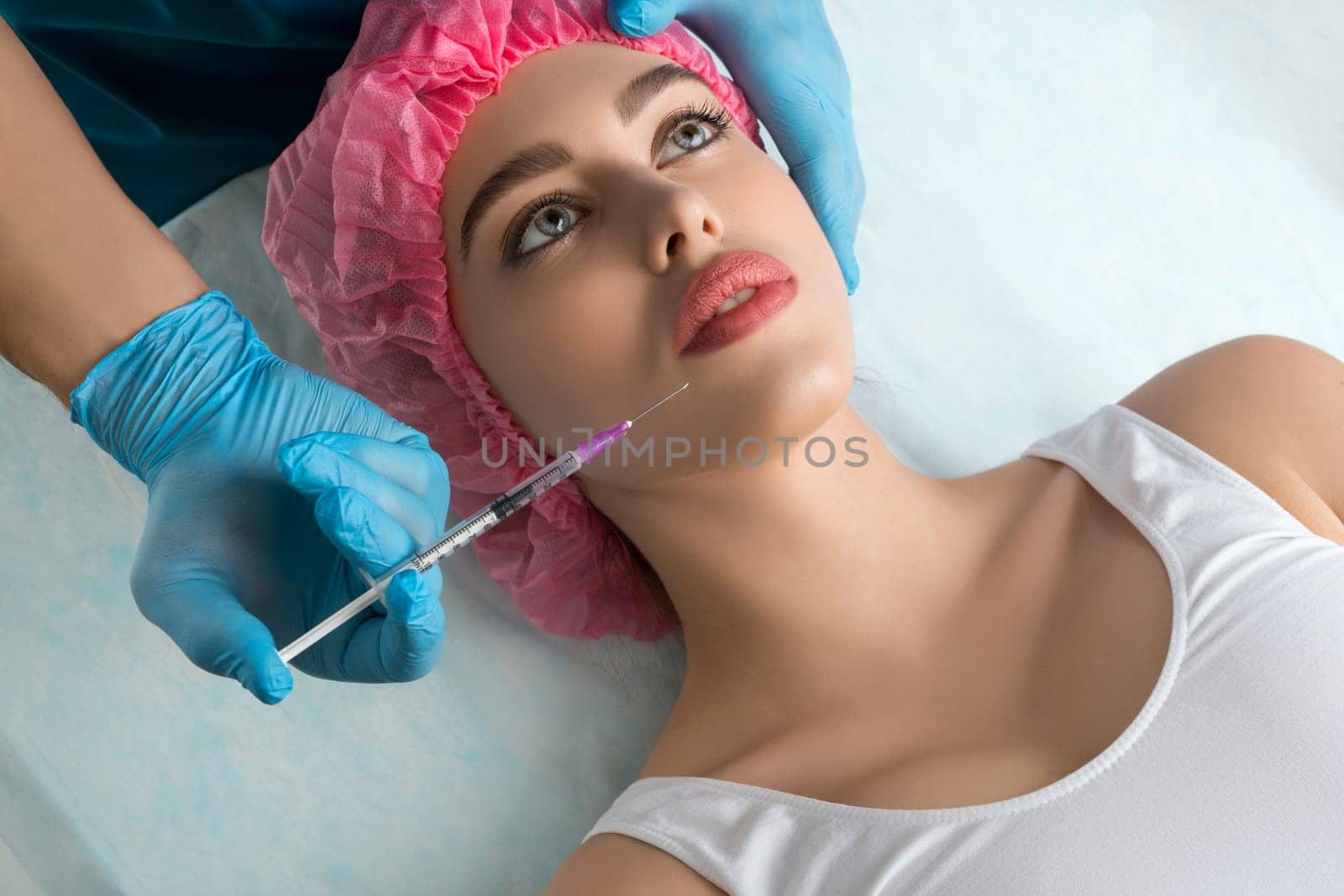 Girl her head and neck bandaged at plastic surgeon lip injection high angle shot