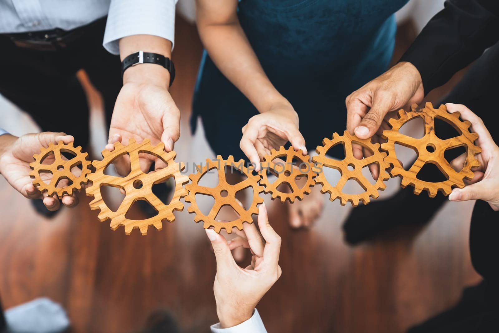 Office worker holding cog wheel as unity and teamwork in corporate workplace concept. Diverse colleague business people showing symbol of visionary system and mechanism for business success. Concord