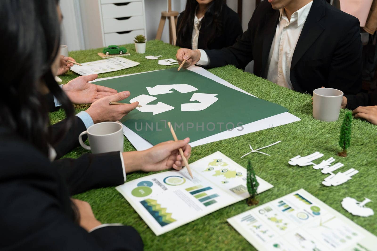 Recycle icon on meeting table with business people. Quaint by biancoblue