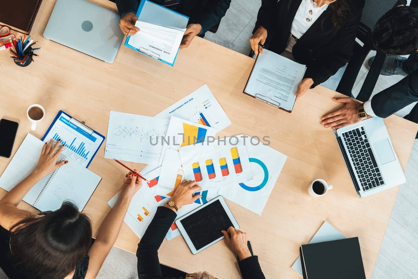 Business people group meeting shot from top view in office . Profession businesswomen, businessmen and office workers working in team conference with project planning document on meeting table . Jivy