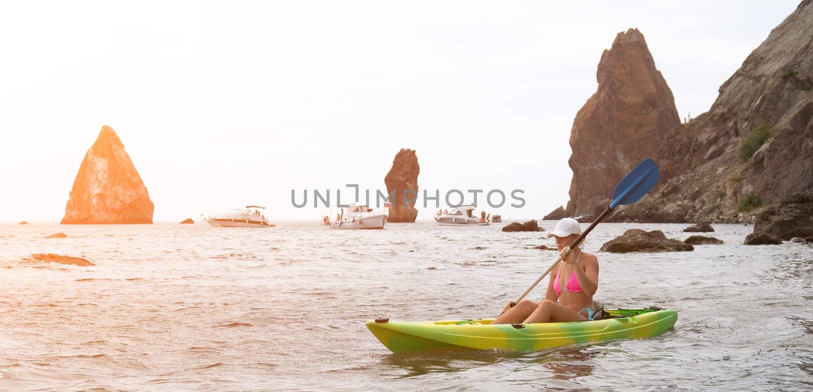 Woman kayak sea. Happy tourist enjoy taking picture outdoors for memories. Woman traveler posing in kayak canoe at sea surrounded by volcanic mountains, sharing travel adventure in kayak by panophotograph