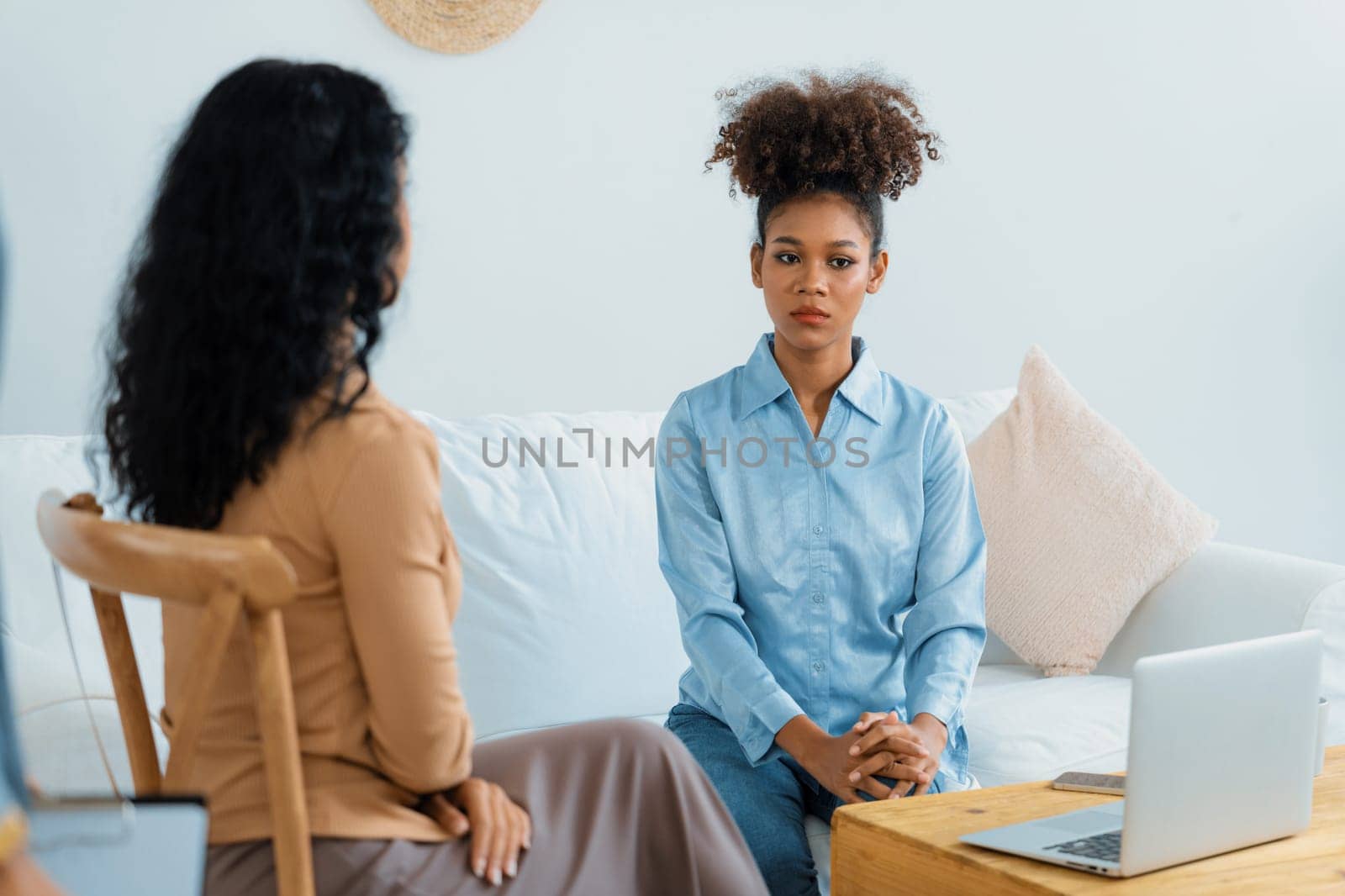 Sad PTSD woman patient in crucial therapy for mental health with psychologist, depression or grief after life failure. Frustrated trauma young woman talking to a psychologist about emotion in clinic