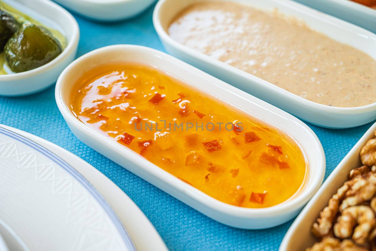 Orange jam in a white porcelain bowl on the breakfast table by Sonat